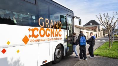Photo d'un bus floqué Grand Cognac avec des élèves en train de monter 