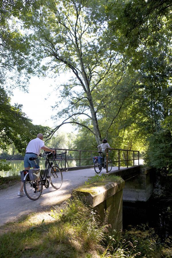 photo de deux cyclistes traversant un pont situé au dessus du fleuve charente dans les environs de Cognac