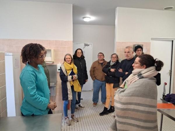 Des personnes visitent une cuisine de restauration collective 